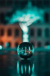 Glaskugel mit Spiegelung von Gebäuden und Lichtern bei Nacht