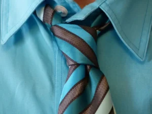 Blaues Hemd mit gestreifter Krawatte, geknotet im Windsor-Stil
