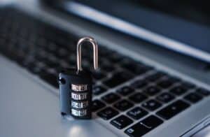 Offenes Zahlenschloss auf Laptop-Tastatur, Symbol für Cyberkriminalitätsgefahr